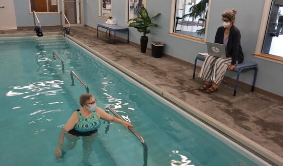 A therapist and patient do arm work in the aquatic therapy pool.