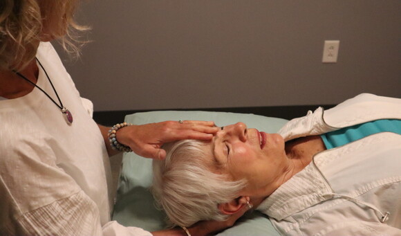 A physical therapist performs Craniosacral Therapy on a patient