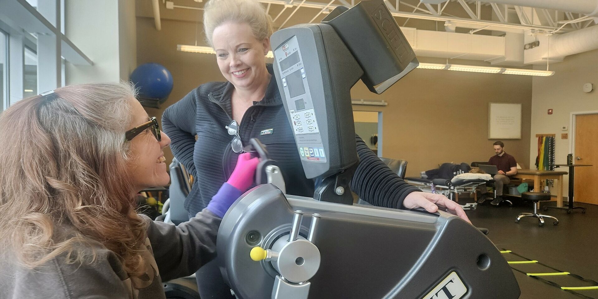 A physical therapist and a patient walk in the clinic