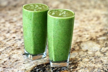 A photo of two glasses filled with green smoothies