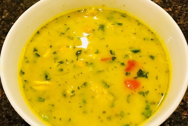 A photo of a bowl of turmeric chickpea chicken soup