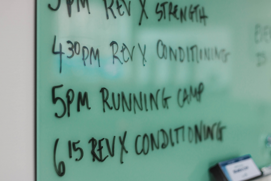 A photo of a white board with a list of exercises written on it
