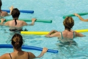 Patients in the aquatic therapy pool exercise with pool equipment