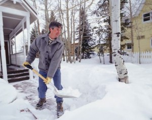 A photo of a man shovelling snow.