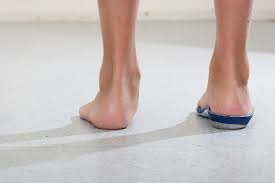 A photo of two feet, one with a support insole.
